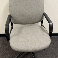 Grey fabric office chair with black armrests and base